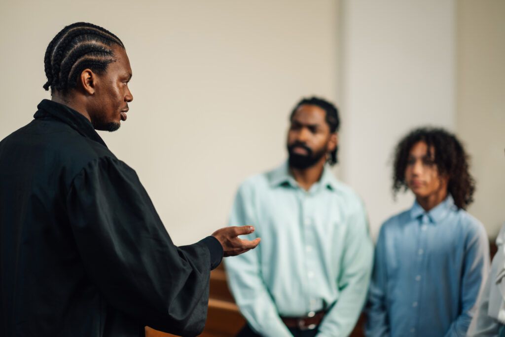 A judge or court official addressing individuals in a courtroom, illustrating proper courtroom etiquette and respectful conduct.