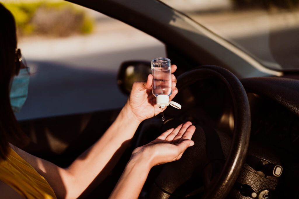 Driver applying hand sanitizer inside a vehicle, representing police investigations into drug impaired driving in Ontario.
