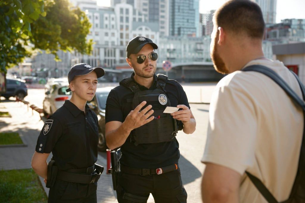 Patrol policeman and policewoman checking personal documents of citizen