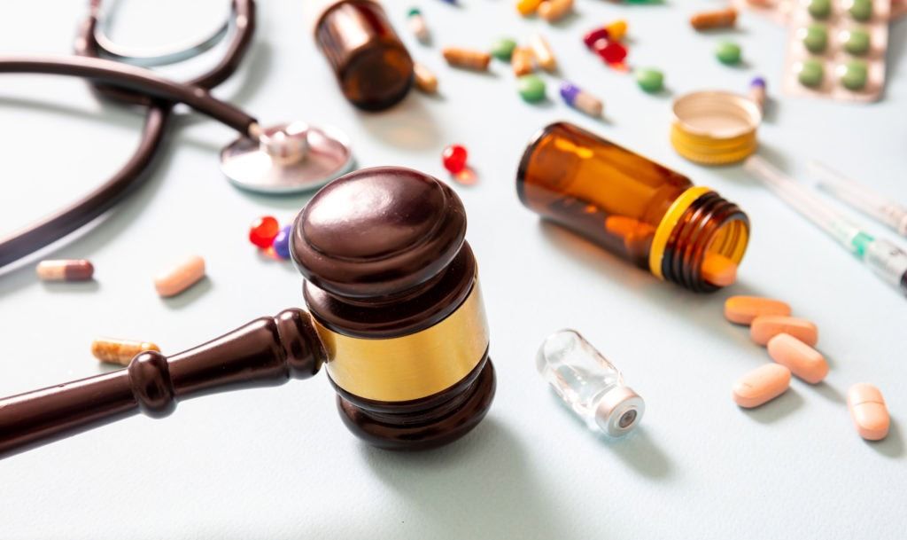 Health and Medicine legal issues. Judge gavel and medication, blue background
