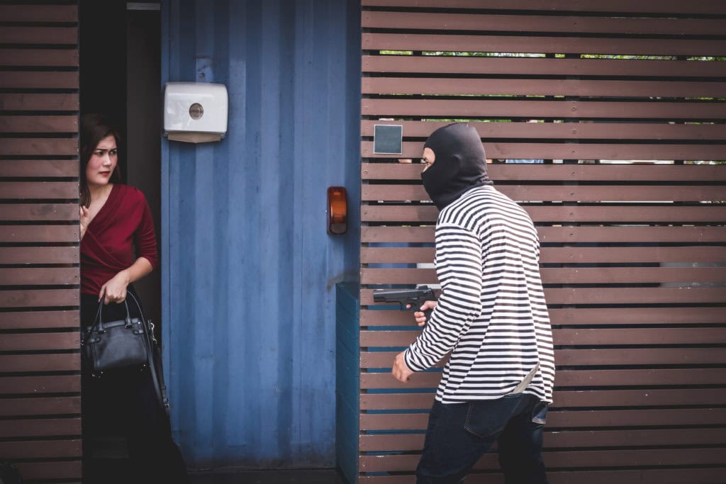 Thief is looking at an asian woman who is in a toilet alone beca