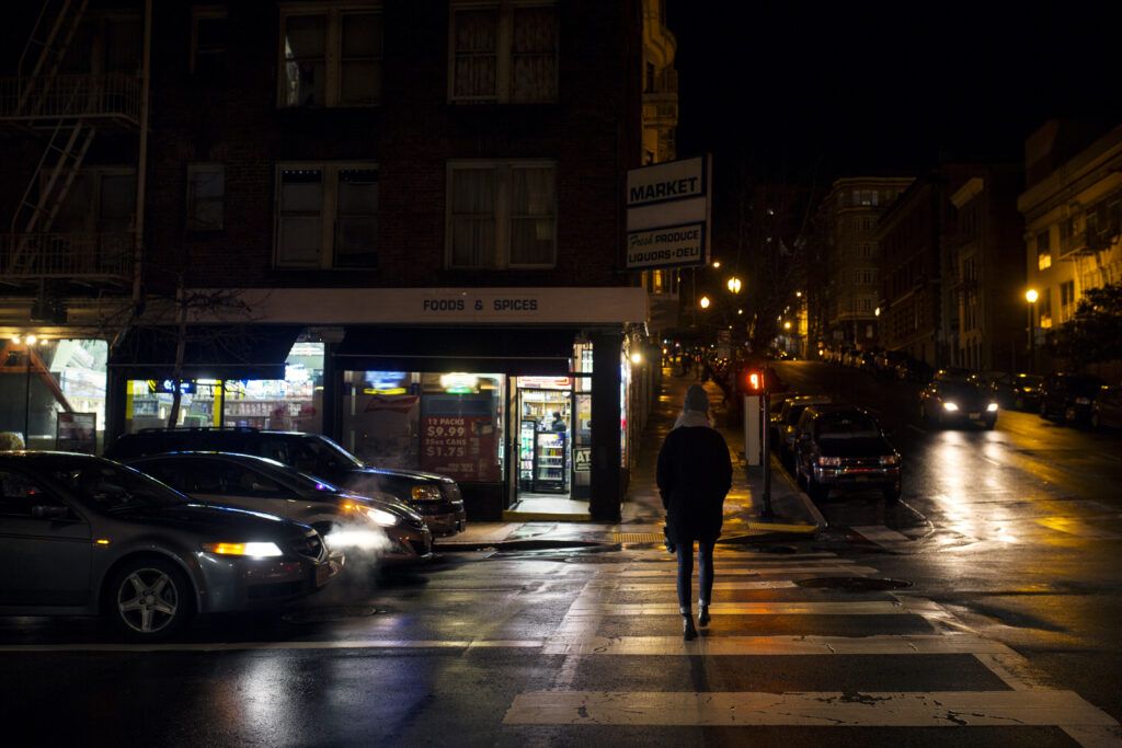 Woman walking alone at night in an urban street, symbolizing personal safety concerns and the legal restrictions on self-defense tools in Canada