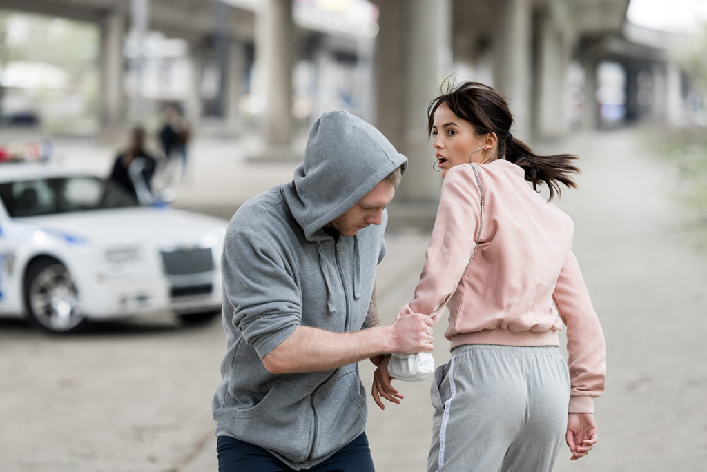 robber stealing handbag from pedestrian