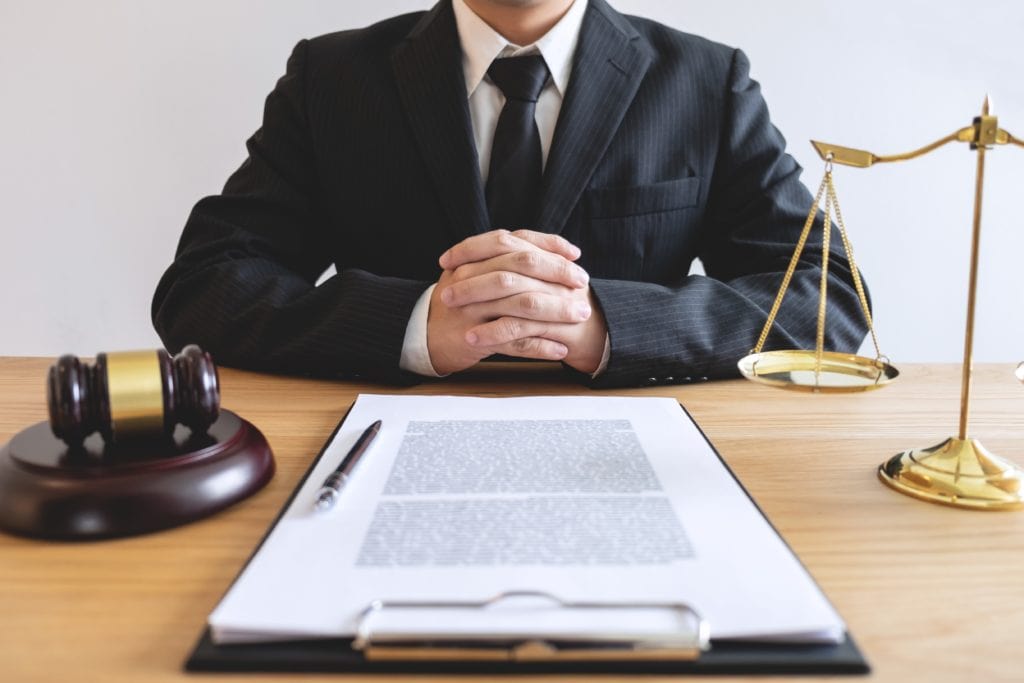 lawyer sitting with gavel and court documents on desk