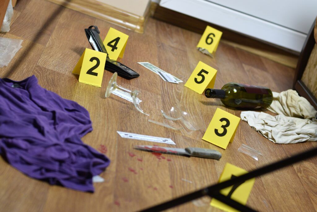 Crime scene evidence markers surrounding a knife and broken glass, representing an assault with a weapon investigation in Canada.