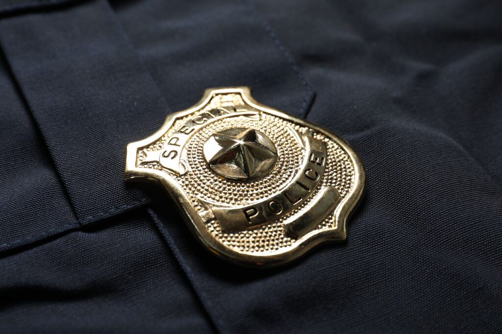 Close up of a police badge on a dark uniform, representing charges and penalties for assaulting a peace officer in Canada.
