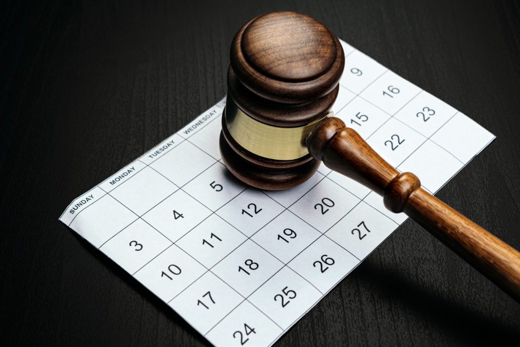 Wooden mallet on calendar page on table